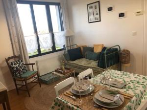 a living room with a table and a couch at Les Hortensias in Amiens