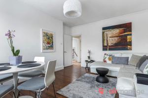 a living room with a white couch and a table at West Kensington 2Bed Flat in London
