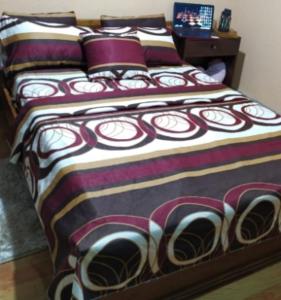 1 dormitorio con 1 cama con una manta colorida en Edificio Carei, en La Troncal