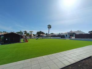 park z zieloną trawą i placem zabaw w obiekcie Cozy Colorado pool view #3 w mieście Maspalomas
