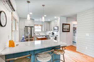 a kitchen with white cabinets and a blue island at Virginia Retreat with Porch and Grill, Near Beaches! in Wachapreague