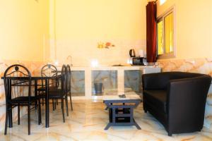a living room with a table and chairs and a kitchen at Studio à 2 pas de l'aéroport in Saint-Louis
