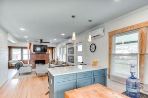 a kitchen with blue cabinets and a living room at Virginia Retreat with Porch and Grill, Near Beaches! in Wachapreague