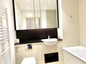 倫敦的住宿－Modern London Excel 2 Bedrooms 2 Bathrooms, Parking, Kitchen, Lounge, Balcony Apartment，白色的浴室设有水槽和镜子