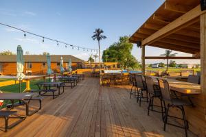 una terraza con mesas, sillas y sombrillas en The Lodge at Angostura, en Hot Springs