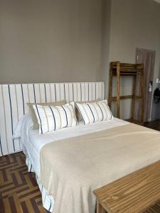 1 cama grande con almohadas blancas en una habitación en Hostel New Time en Salta