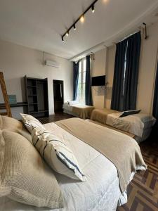 1 dormitorio con 2 camas y TV. en Hostel New Time en Salta