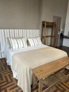 1 dormitorio con 1 cama grande y mesa de madera en Hostel New Time en Salta