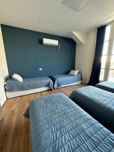1 dormitorio con 2 camas y pared azul en Hostel New Time en Salta