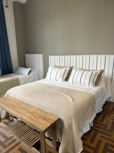 Hostel New Time في سالتا: سرير كبير مع وسائد بيضاء في الغرفة