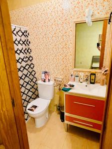 a woman is sitting on a toilet in a bathroom at VINO DE MAYO in Caravaca de la Cruz