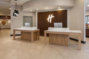 a lobby with two tables in a building at Holiday Inn El Paso West – Sunland Park, an IHG Hotel in El Paso