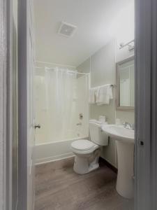a white bathroom with a toilet and a sink at Best Motel in Seattle