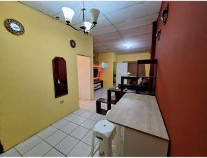 una camera con cucina con bancone e orologio sul muro di Casa Las Azucenas a Sonsonate