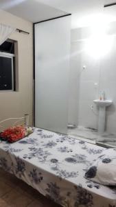 een slaapkamer met een bed met een glazen wand bij Hospedagem do Marcão in Belo Horizonte
