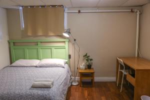 a bedroom with a bed with a green headboard at Cozy stay close to Merivale in Ottawa