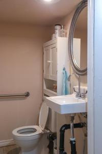 a bathroom with a toilet and a sink and a mirror at Cozy stay close to Merivale in Ottawa
