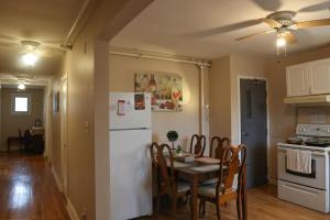 a kitchen with a table and a white refrigerator at Cozy stay close to Merivale in Ottawa