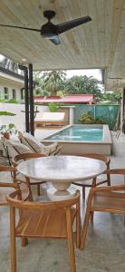 a patio with a table and chairs and a pool at Walk to the Beach! House in private compound! Pool, Kitchen, AC, Wi-Fi in Mal País