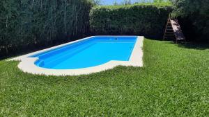 une piscine bleue dans l'herbe avec une échelle dans l'établissement Casa en San Lorenzo, à San Lorenzo