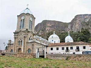 una vieja iglesia con una torre de reloj en una colina en Edificio Carei, en La Troncal