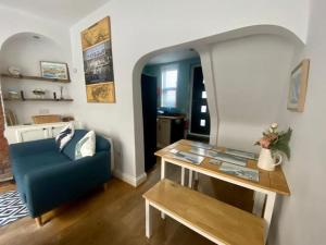 a living room with a blue couch and a table at Harbour Hideaway, Scarborough. Old Town in Scarborough