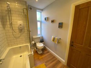 a bathroom with a tub and a toilet and a shower at Harbour Hideaway, Scarborough. Old Town in Scarborough +51 photos