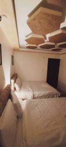 a bedroom with two beds and a ceiling at pyramids Alaaeldeinn in Cairo