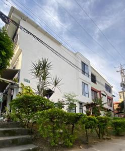 a white building with some plants in front of it at BORA - Apto 101Tu espacio fuera de casa in Ibagué +13 photos