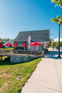 a restaurant with red umbrellas next to a sidewalk at Relax on White Lake at Peninsula Point in Montague +11 photos