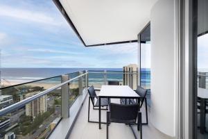 a balcony with a table and chairs and the ocean at ULTIQA Signature at Broadbeach in Gold Coast