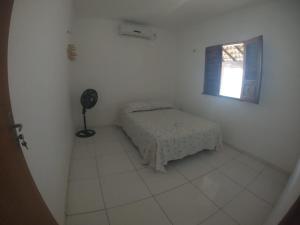 um quarto branco com uma cama e uma janela em CASA PORTO em Luís Correia
