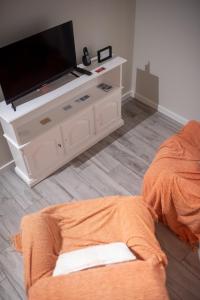 ein Wohnzimmer mit einem Flachbild-TV auf einem Stand in der Unterkunft Vista do Baixio in Vila Franca do Campo