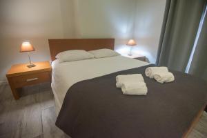 ein Schlafzimmer mit einem großen Bett mit Handtüchern darauf in der Unterkunft Vista do Baixio in Vila Franca do Campo