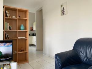 a living room with a couch and a television at La Siguine in Gourbeyre