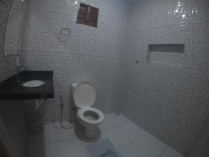 uma casa de banho branca com um WC e um lavatório em CASA PORTO em Luís Correia