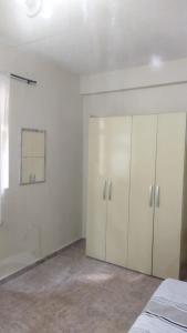 ein Schlafzimmer mit weißen Schränken und einer weißen Wand in der Unterkunft Hospedagem do Marcão in Belo Horizonte