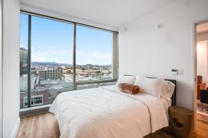 a bedroom with a white bed and large windows at NEW 1BR Luxury Highrise in Los Angeles