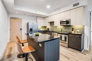 a large kitchen with a counter and a refrigerator at NEW 1BR Luxury Highrise in Los Angeles