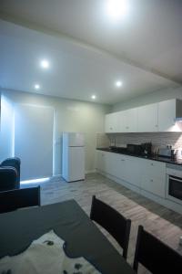 eine Küche mit weißen Schränken und einem weißen Kühlschrank in der Unterkunft Vista do Tagarete in Vila Franca do Campo