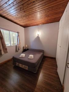 una camera con letto e soffitto in legno di Departamento Castello a El Bolsón