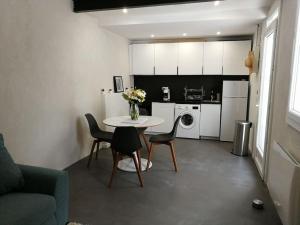 a living room with a table and chairs and a kitchen at Villa au Calme avec Extérieur et parking gratuit aux portes d'Aix et Marseille Emplacement idéal in Marseille