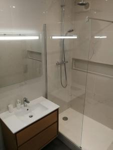 La salle de bains blanche est pourvue d'une douche et d'un lavabo. dans l'établissement Villa au Calme avec Extérieur et parking gratuit aux portes d'Aix et Marseille Emplacement idéal, à Marseille