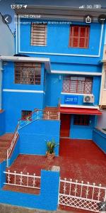 a blue building with a red floor and stairs at Pousada Central in Bragança Paulista