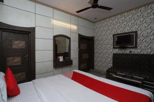 a bedroom with a bed and a flat screen tv at OYO Hotel Vanshika in Agra