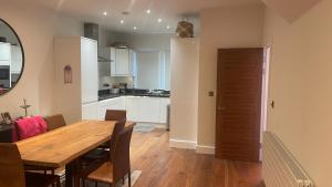 a kitchen and dining room with a wooden table at Modern and Unique Home in London, Chiswick in London