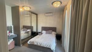 een slaapkamer met een bed en een grote spiegel bij Modern and Unique Home in London, Chiswick in Londen