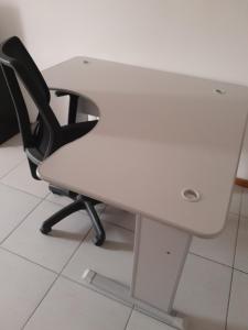 una scrivania bianca con una sedia nera seduta sotto di essa di APARTAMENTO PARA FERIAS BLUMENAU a Blumenau