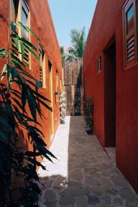 an alley between two orange buildings with a gate at Las Dunas Beach Guest House in Juan de Acosta