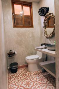 a bathroom with a toilet and a window at Las Dunas Beach Guest House in Juan de Acosta